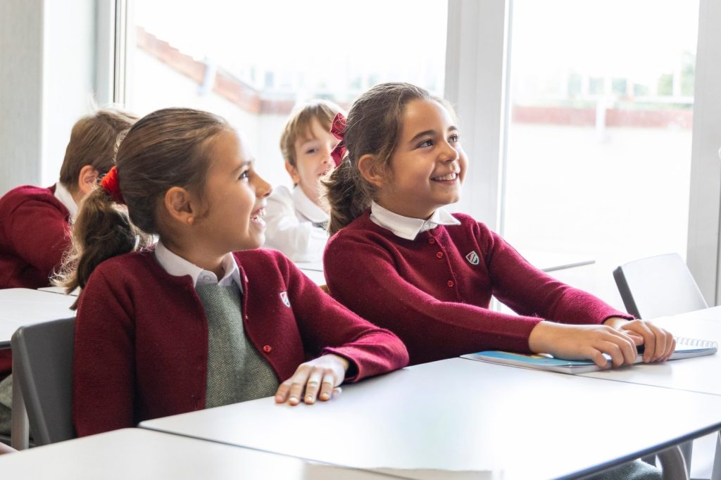 Dos alumnas sonriendo atentas en clase en Dallington School, colegio británico en Madrid