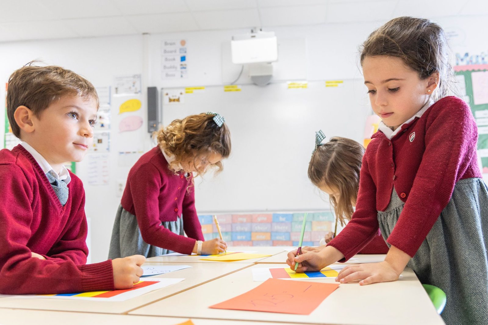 Alumnos de Primary escribiendo en las mesas de clase en Dallington School
