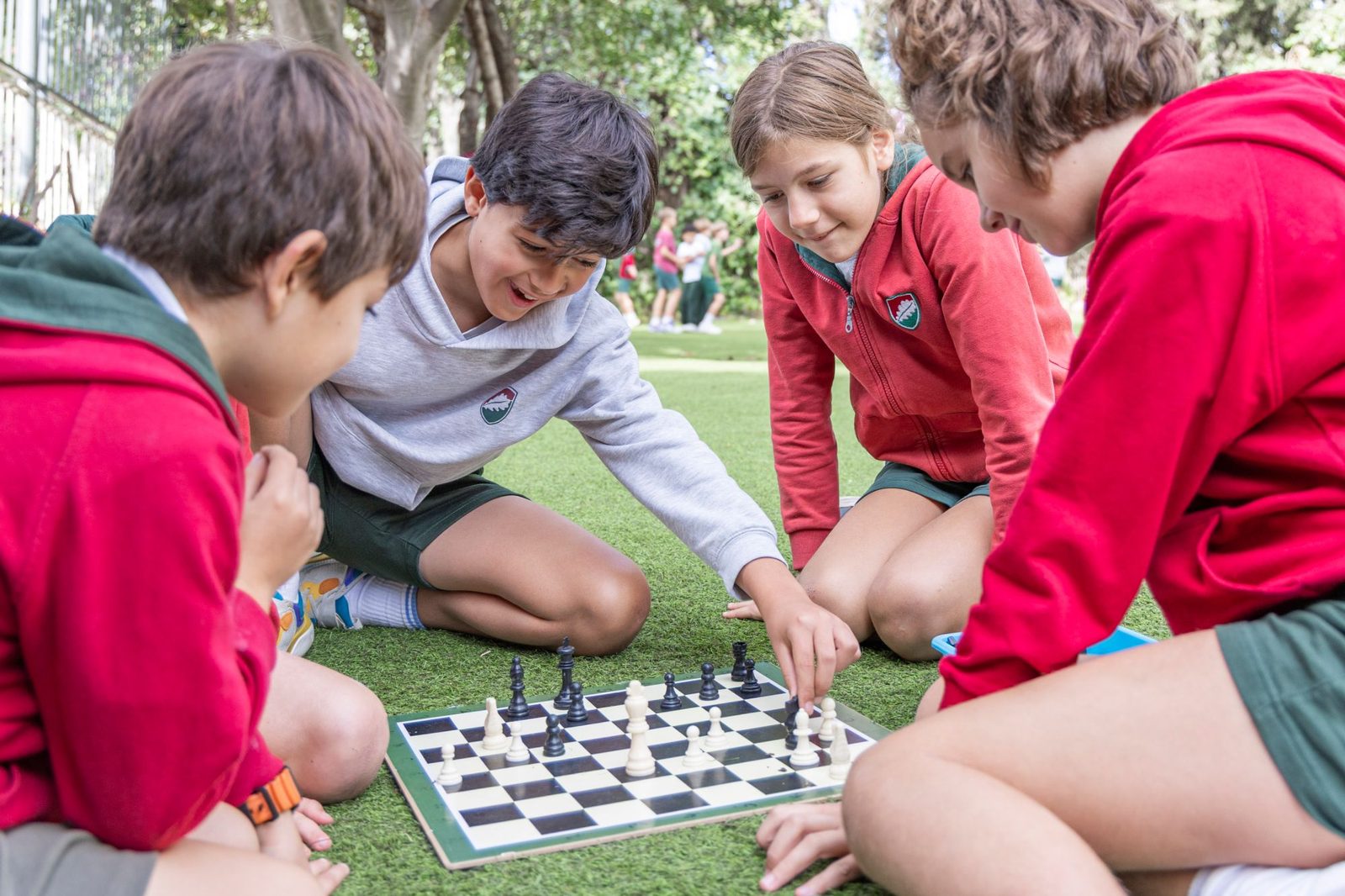 Cuatro niños jugando una partida de ajedrez al aire libre en Dallington School, colegio británico en Madrid