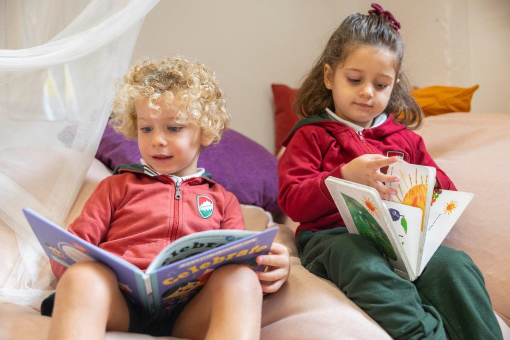 Dos niños pequeños leyendo libros en inglés en Dallington School, colegio bilingüe en Madrid